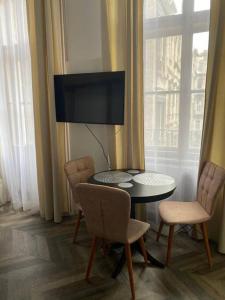 een kamer met een tafel en stoelen en een televisie bij Apartament in stil unic langa Primaria Arad in Arad