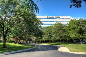 Una carretera frente a un edificio con un cartel. en Embassy Suites by Hilton Detroit Troy Auburn Hills, en Troy