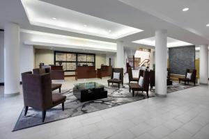 eine Lobby eines Hotels mit Stühlen und einem Tisch in der Unterkunft Embassy Suites by Hilton Detroit Troy Auburn Hills in Troy