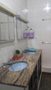 Baño con 2 lavabos y espejo en Pousada Corumba Center, en Corumbá