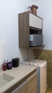 a kitchen with a counter top with a microwave at Pousada Corumba Center in Corumbá