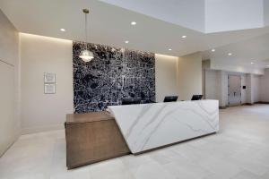 a lobby with a reception desk and a black and white wall at Embassy Suites by Hilton Atlanta Perimeter Center in Atlanta
