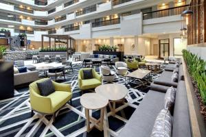 a lobby of a hotel with tables and chairs at Embassy Suites by Hilton Atlanta Perimeter Center in Atlanta