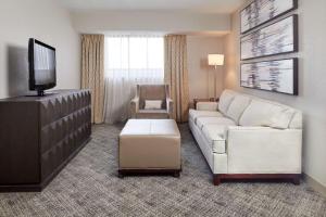 ein Wohnzimmer mit einem Sofa und einem TV in der Unterkunft DoubleTree Suites by Hilton Nashville Airport in Nashville