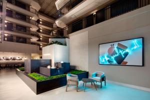 a lobby with two chairs and a tv on the wall at Embassy Suites by Hilton San Rafael Marin County in San Rafael