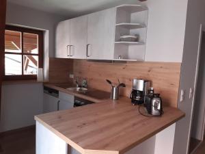 a kitchen with white cabinets and a wooden counter top at Weingut Engelhardt in Röttingen