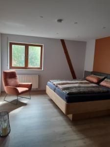 een slaapkamer met een bed en een stoel erin bij Weingut Engelhardt in Röttingen