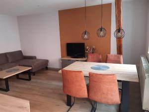 a dining room with a table and chairs and a couch at Weingut Engelhardt in Röttingen