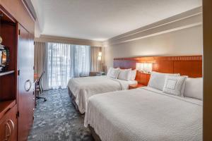 um quarto de hotel com duas camas e uma janela em Courtyard by Marriott Jacksonville Beach Oceanfront em Jacksonville Beach