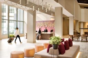 a lobby with a couch and stools and a bar at Embassy Suites by Hilton Phoenix Downtown North in Phoenix