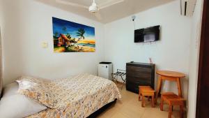 a bedroom with a bed and a tv and a table at Hotel Olas in San Andrés