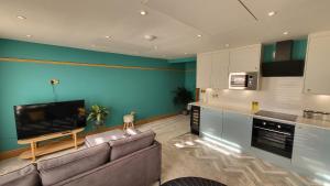 Sunset Point Apts - North Shore Suite في مارغايْت: غرفة معيشة مع أريكة وتلفزيون بشاشة مسطحة
