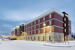 un grand bâtiment rouge avec de la neige devant lui dans l'établissement Home2 Suites by Hilton Anchorage/Midtown, à Anchorage