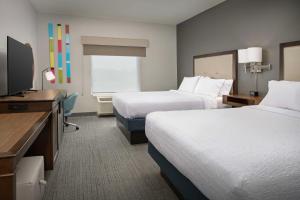 a hotel room with two beds and a flat screen tv at Hampton Inn & Suites Portland/Hillsboro-Evergreen Park in Hillsboro