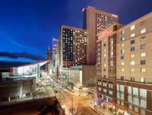 een skyline van de stad 's nachts met hoge gebouwen bij Hilton Garden Inn Denver Downtown in Denver