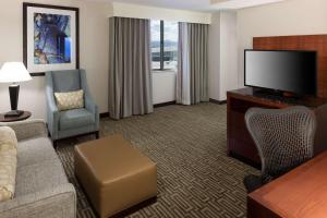 a hotel room with a couch and a television at Hilton Garden Inn Denver Downtown in Denver