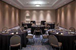 une salle de conférence avec des tables et des chaises devant un mur dans l'établissement Hilton Garden Inn Denver Downtown, à Denver