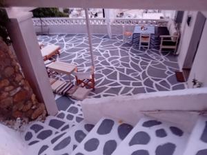 a patio with a patterned floor with chairs and tables at Vasiliki Skyros Castle View in Skiros