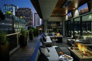 a rooftop patio with couches and tables on a building at Hilton Garden Inn Seattle Bellevue Downtown, WA in Bellevue