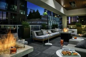 un patio con sofás y una chimenea en un edificio en Hilton Garden Inn Seattle Bellevue Downtown, WA, en Bellevue