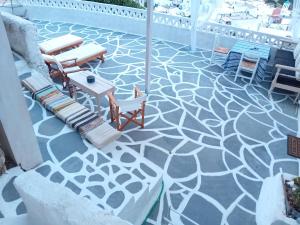 a patio with a concrete floor with chairs and tables at Vasiliki Skyros Castle View in Skiros