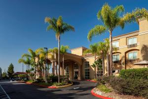 un bâtiment avec des palmiers en face de celui-ci dans l'établissement Hilton Garden Inn San Diego/Rancho Bernardo, à Rancho Bernardo