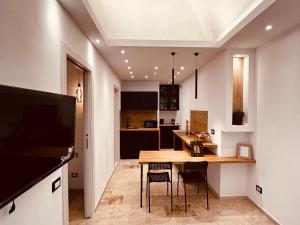 Una cocina y un comedor con mesa y sillas de madera. en Casa Nada, en Porto Torres