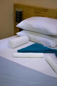 a bed with white pillows and towels on it at Ninos K.Guraidhoo in Guraidhoo