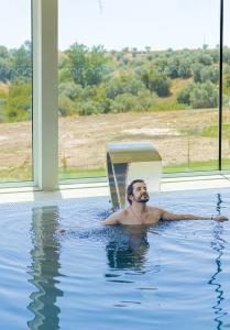 a man in a swimming pool in a house at Sleep & Nature Hotel in Lavre
