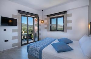 a bedroom with a bed and a tv and windows at Villa Ioanna NC , an upper class accommodation in Próvarma +42 photos