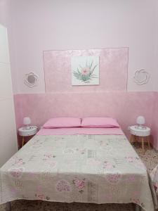 1 dormitorio con 1 cama con pared de color rosa en Holiday home La Rinascita, en Bagheria