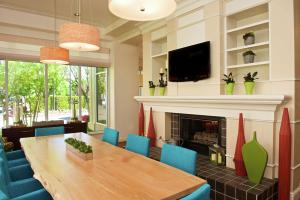 a dining room with a table and a fireplace at Hilton Garden Inn Seattle/Renton in Renton