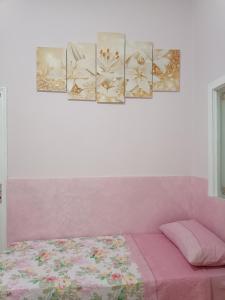 a bedroom with four paintings on the wall at Holiday home La Rinascita in Bagheria