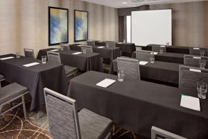 una sala de conferencias con mesas y sillas negras y una pantalla en Homewood Suites Nashville/Brentwood, en Brentwood