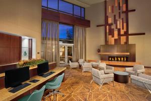 a lobby with a desk with two monitors and chairs at Courtyard by Marriott Dallas Allen at Allen Event Center in Allen