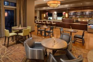 a restaurant with tables and chairs and a bar at Courtyard by Marriott Dallas Allen at Allen Event Center in Allen