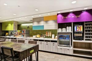 a fast food restaurant with a table and a counter at Home2 Suites By Hilton Daytona Beach Speedway in Daytona Beach