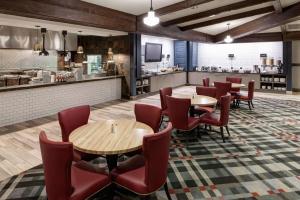 um restaurante com mesas e cadeiras e uma cozinha em Embassy Suites Anchorage em Anchorage