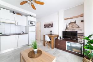 a kitchen and living room with a tv and a table at Apartamento cerca de una de las mejores playas. in Roquetas de Mar