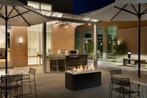 eine Terrasse mit einer Feuerstelle sowie Tischen und Stühlen in der Unterkunft Homewood Suites By Hilton SLC/Draper in Draper