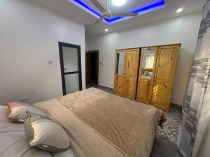 ein Schlafzimmer mit einem großen Bett mit blauer Decke in der Unterkunft J2 Villa in Sukuta