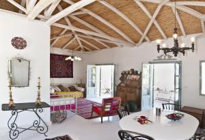 uma sala de estar com paredes brancas e um tecto de madeira em Salvia em Kardamili