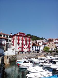 a group of boats are docked in a harbor at ATICO TORRONTERO in Mundaka