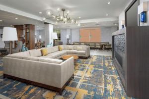 ein großes Wohnzimmer mit Sofas und einem TV in der Unterkunft Hilton Garden Inn Westchester Dobbs Ferry in Dobbs Ferry