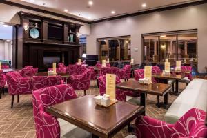 a restaurant with tables and chairs and pink chairs at Hilton Garden Inn Jacksonville Downtown Southbank in Jacksonville