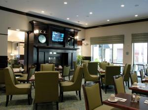 um restaurante com mesas e cadeiras e um relógio em Hilton Garden Inn Jacksonville Downtown Southbank em Jacksonville