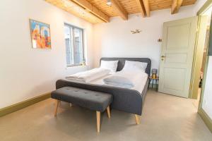 - une chambre avec un lit doté d'un pouf dans l'établissement Ferienwohnung Schiffbrücke 40, à Flensbourg