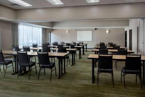 uma grande sala com mesas e cadeiras e um quadro branco em Courtyard by Marriott Boston Norwood/Canton em Norwood