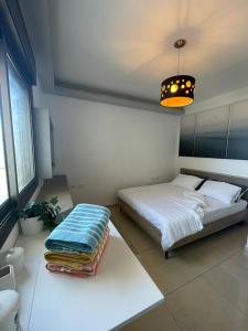 a bedroom with two beds and a table with towels at Roy Vacation Home in Rishon LeẔiyyon