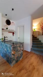 a kitchen with a counter and a staircase in a room at Il Giardino Fiorito in Trevignano Romano